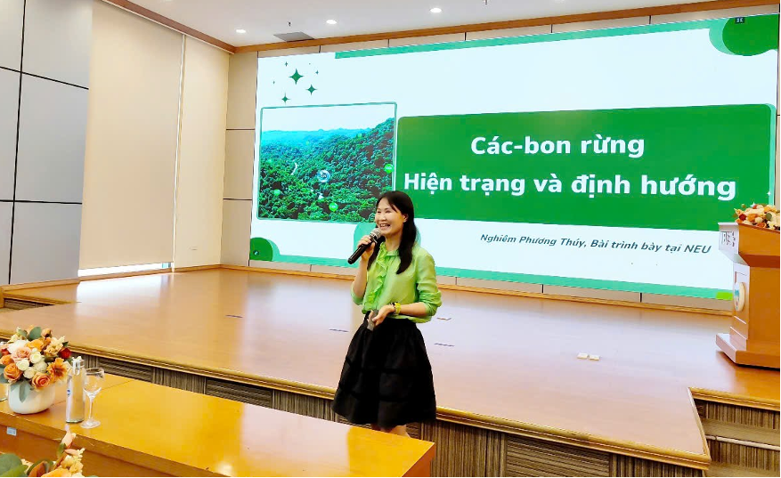 Diễn giả Nghiêm Phương Thúy đang thuyết trình về chủ đề carbon rừng tại hội thảo, với màn hình chiếu nội dung thuyết trình phía sau.