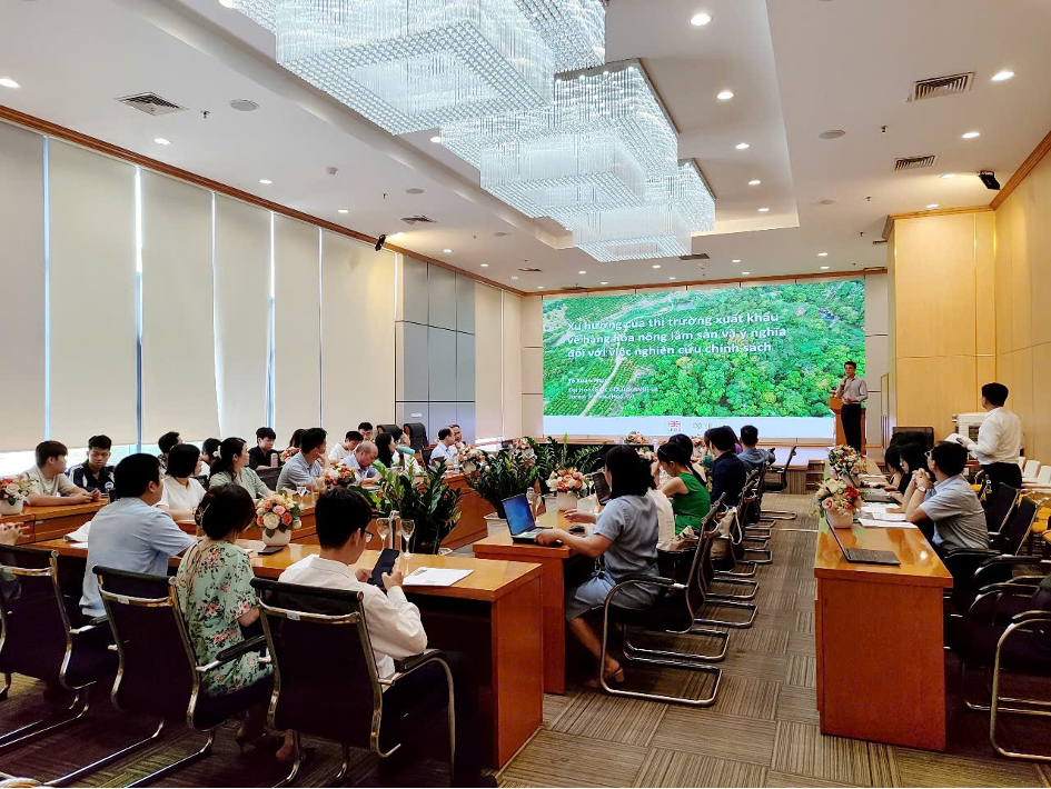 Hình ảnh buổi tọa đàm khoa học về thị trường xuất khẩu và phát triển bền vững tại Trường Đại học Kinh tế Quốc dân, với nhiều người tham dự và màn hình trình chiếu nội dung liên quan.