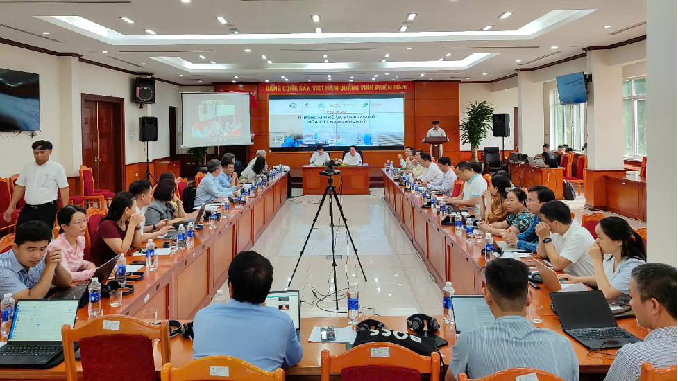 Một buổi tọa đàm về thương mại gỗ giữa Việt Nam và Mỹ, với nhiều đại biểu tham dự tại một phòng họp, có màn hình trình chiếu thông tin và các thiết bị âm thanh.