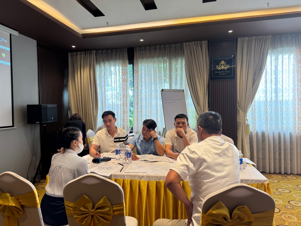 Cuộc họp thảo luận giữa các đại biểu về Sổ tay hướng dẫn hộ cao su tiểu điền và đại lý tuân thủ EUDR, trong một không gian khép kín với bàn họp và tài liệu liên quan.