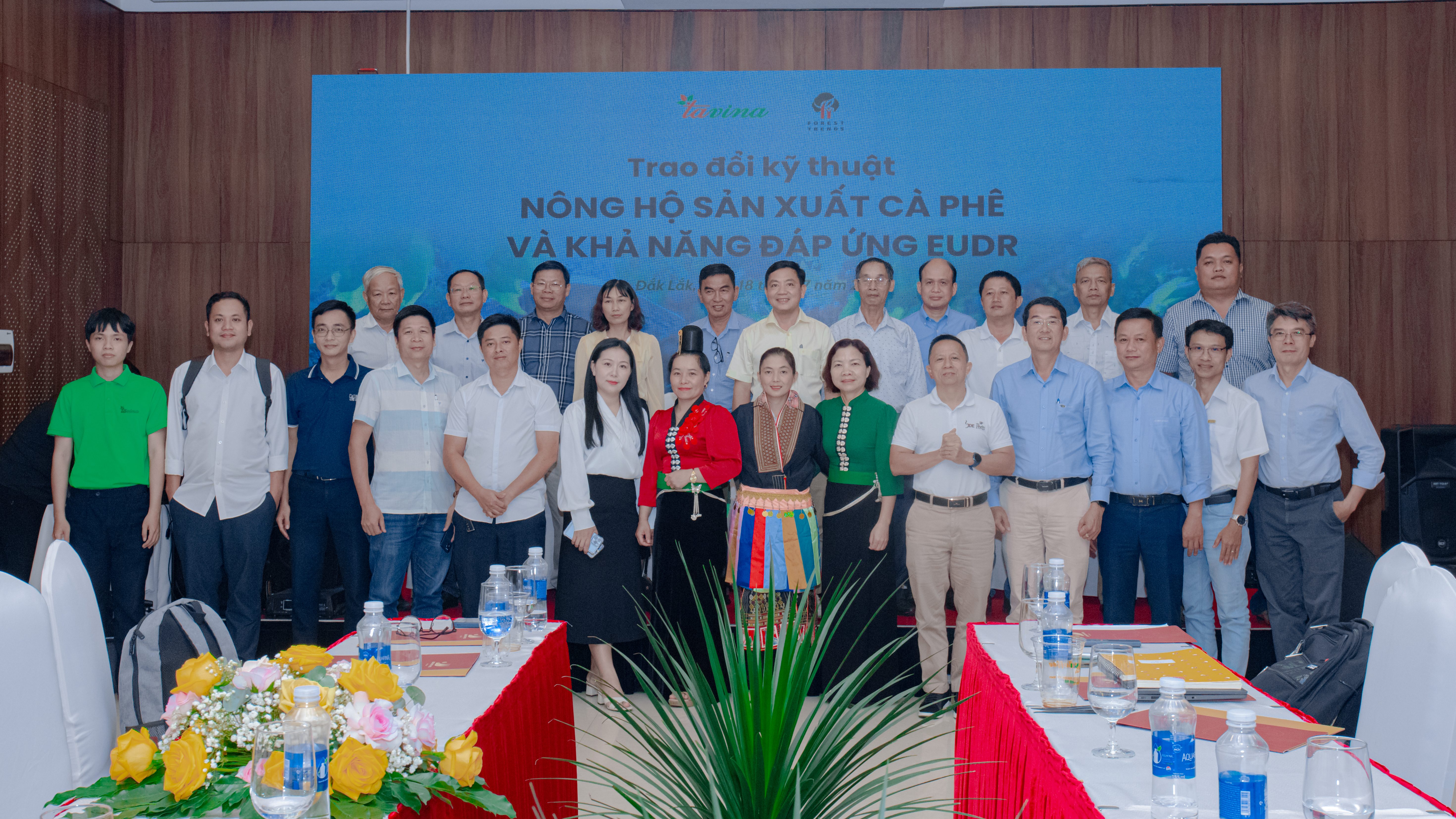 A group of participants posed for a photo at a technical exchange event on coffee production and EU regulations, with a banner in the background.